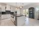 Close up of a bright kitchen with a large island and a stainless steel farmhouse sink with gold faucet at 8504 Mystic Night Ave, Las Vegas, NV 89143