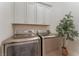 Laundry room with stainless steel washer and dryer with light colored cabinets at 8504 Mystic Night Ave, Las Vegas, NV 89143