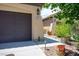Two car garage with desert landscaping featuring a brown door and beige siding at 8873 Briar Bay Dr, Las Vegas, NV 89131
