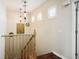 Upstairs hallway with decorative lighting, a wooden staircase, and plantation shutters on the windows at 8873 Briar Bay Dr, Las Vegas, NV 89131