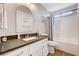 Clean bathroom with dark countertops, white vanity, and a shower-tub combo at 9328 Jumpin Juniper Ave, Las Vegas, NV 89129