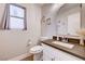 Well-lit half bathroom featuring a modern vanity with a white sink and dark countertop at 9328 Jumpin Juniper Ave, Las Vegas, NV 89129