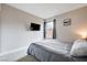 Modern bedroom with a flat screen TV, neutral colors, and a comfortable gray bed at 9328 Jumpin Juniper Ave, Las Vegas, NV 89129