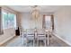 Bright dining room features modern chandelier, neutral paint, and large windows at 9328 Jumpin Juniper Ave, Las Vegas, NV 89129