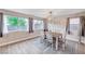 Bright dining room features modern chandelier, neutral paint, and three large windows at 9328 Jumpin Juniper Ave, Las Vegas, NV 89129