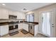 Well-lit kitchen boasts stainless steel appliances, ample white cabinetry, and convenient backyard access at 9328 Jumpin Juniper Ave, Las Vegas, NV 89129