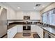 Kitchen featuring stainless steel appliances, white cabinets, black countertops, and wood-look flooring at 9328 Jumpin Juniper Ave, Las Vegas, NV 89129