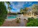 Serene backyard with a fenced pool, rock features, and lush greenery, creating a private oasis at 9772 Galahad Point Ct, Las Vegas, NV 89147