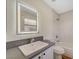 A bright bathroom has a tiled shower over the tub, a sink, and an illuminated mirror at 9772 Galahad Point Ct, Las Vegas, NV 89147
