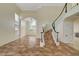 Grand foyer featuring tile floors and a curved staircase with rod iron details at 9772 Galahad Point Ct, Las Vegas, NV 89147