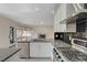 Bright kitchen with a kitchen island, stainless steel appliances, and views to the living room at 9772 Galahad Point Ct, Las Vegas, NV 89147