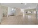 Open-concept living room with stairs, tile flooring, and natural lighting from large windows at 9772 Galahad Point Ct, Las Vegas, NV 89147