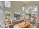 Bright living room boasts neutral colors, modern furniture, tall windows, and an open dining area at 9772 Galahad Point Ct, Las Vegas, NV 89147