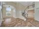 Bright living room features high ceilings, an elegant staircase, and neutral tile flooring at 9772 Galahad Point Ct, Las Vegas, NV 89147