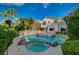 Backyard with a private pool and jacuzzi surrounded by decorative rocks, lush greenery and a partial view of the home's exterior at 9772 Galahad Point Ct, Las Vegas, NV 89147