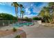 Beautiful pool area with rock accents, surrounded by lush landscaping and palm trees, perfect for leisure at 9772 Galahad Point Ct, Las Vegas, NV 89147