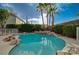 Refreshing pool with rock features and a spa, surrounded by lush landscaping for ultimate relaxation at 9772 Galahad Point Ct, Las Vegas, NV 89147