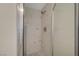 Modern shower with marble-look tile, rainfall showerhead, and glass door at 9772 Galahad Point Ct, Las Vegas, NV 89147