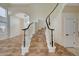 Elegant staircase with dark wood railing leads to the upper level, showcasing open floor plan at 9772 Galahad Point Ct, Las Vegas, NV 89147