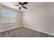 Cozy bedroom with plush gray carpeting, a ceiling fan, and natural light from a window at 113 Elm St, Henderson, NV 89015