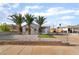 Charming gray single-story home featuring desert landscaping and mature palm trees in the front yard at 113 Elm St, Henderson, NV 89015