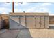 Close-up of the storage shed with three large doors and a concrete and gravel base at 113 Elm St, Henderson, NV 89015