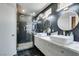 Well-lit bathroom featuring dual sinks, modern fixtures, and a walk-in shower with black hexagon tile at 1352 Angel Falls St, Las Vegas, NV 89142
