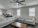 Bright living room features a large gray sectional, ceiling fan, and natural light creating a welcoming atmosphere at 1352 Angel Falls St, Las Vegas, NV 89142