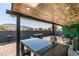 Covered outdoor kitchen with a granite countertop, grill, and lounge area overlooking mountain views at 1352 Angel Falls St, Las Vegas, NV 89142