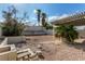 The landscaped backyard provides space for entertainment beneath the pergola and tall palm trees at 1704 Kismet Cir, Las Vegas, NV 89108