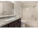 Bathroom featuring granite countertops, dark cabinets, and shower-tub combination at 1704 Kismet Cir, Las Vegas, NV 89108