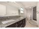 Bathroom vanity with double sinks, granite countertops, and tiled shower at 1704 Kismet Cir, Las Vegas, NV 89108