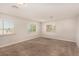 Spacious bedroom features neutral walls, carpet, and three windows, providing ample natural light at 1704 Kismet Cir, Las Vegas, NV 89108