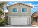 Exterior view of a gray home featuring a two-car garage, an extra parking spot, and clean architecture at 1704 Kismet Cir, Las Vegas, NV 89108