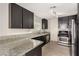 Stylish kitchen with stainless steel appliances, modern countertops, and dark cabinets, with plenty of natural light at 1704 Kismet Cir, Las Vegas, NV 89108