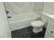 Bathroom features a tub with white marble-like surround and black tiled floor at 1805 Amboy Dr, Las Vegas, NV 89108