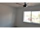 A minimalist bedroom with a ceiling fan and a large window offering natural light at 1805 Amboy Dr, Las Vegas, NV 89108