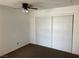 Cozy bedroom features a ceiling fan, carpet, and a closet with sliding doors at 1830 N Pecos Rd # 252, Las Vegas, NV 89115