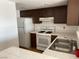 Functional kitchen featuring wood cabinets, white appliances, and tile countertops at 1830 N Pecos Rd # 252, Las Vegas, NV 89115
