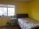 Bedroom features yellow walls and a bright window at 2898 Violet Ln # 0, Henderson, NV 89074