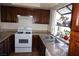 Bright kitchen with tile countertops, dual sink, gas range, wood cabinets, and bright garden window at 2898 Violet Ln # 0, Henderson, NV 89074