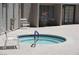 Inviting outdoor spa area with tiled surface, white chairs and a ladder; neutral exterior building nearby at 2898 Violet Ln # 0, Henderson, NV 89074