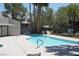Community swimming pool with lounge chairs, trees, blue water, and a nearby seating area at 2898 Violet Ln # 0, Henderson, NV 89074