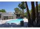 Exterior view of a sparkling community swimming pool with palms, trees, chairs and lounge area at 2898 Violet Ln # 0, Henderson, NV 89074