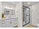 Modern bathroom features white cabinets with gold hardware, sleek mirror, and glass-enclosed shower at 3151 Soaring Gulls Dr # 1179, Las Vegas, NV 89128