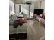 Cozy living room with laminate flooring, featuring sofas and a large wardrobe with mirrors, illuminated by natural light at 4017 Edgeford Pl, Las Vegas, NV 89102