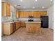 Traditional kitchen featuring an island, black refrigerator, gas range, and wood cabinets at 4905 Apache Valley Ave, Las Vegas, NV 89131