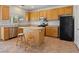 Bright kitchen with stainless steel appliances, wood cabinets, tile flooring, and a center island at 4905 Apache Valley Ave, Las Vegas, NV 89131