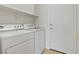 Laundry room with white washer and dryer, shelving, and access door at 4905 Apache Valley Ave, Las Vegas, NV 89131