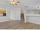 Open-concept living room features wood-look floors, a stairwell, and access to the kitchen at 4905 Apache Valley Ave, Las Vegas, NV 89131